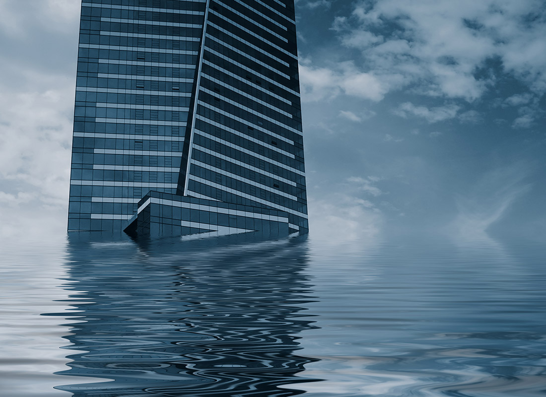 Commercial Flood Insurance - Abstract View of a Tall Building in Partly Submerged Water on a Gloomy Day