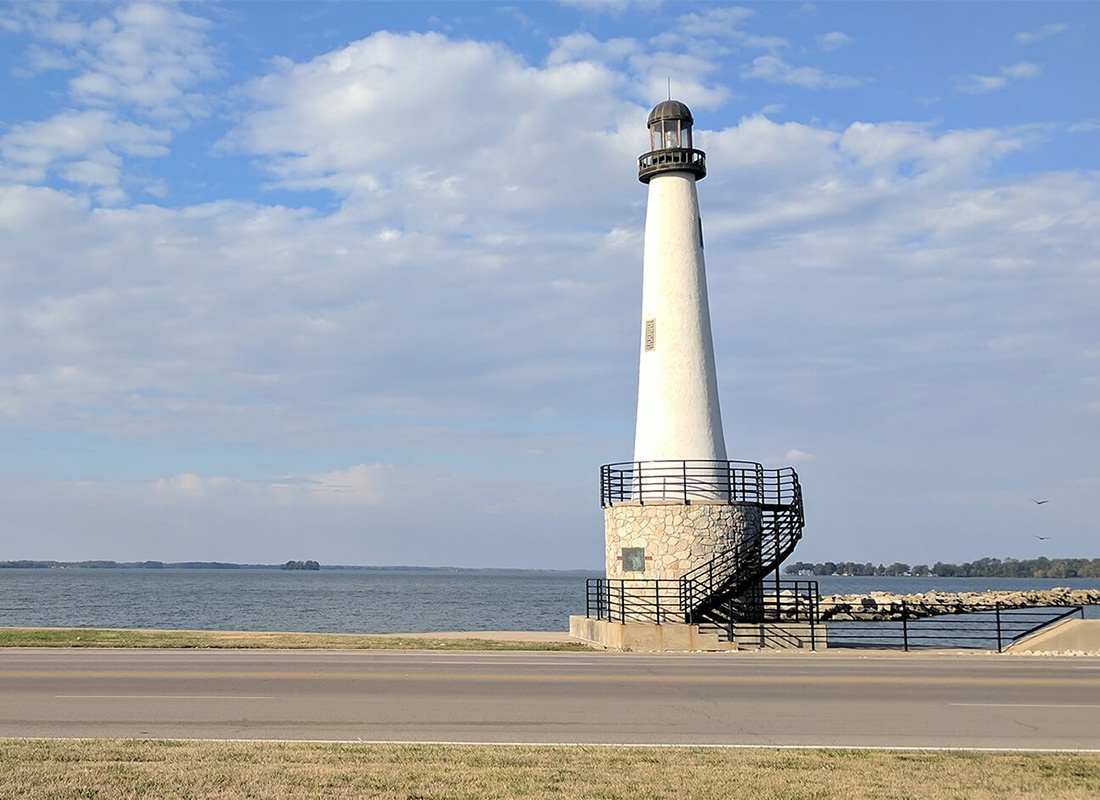 About Our Agency - View of a Lighthouse by the Water Against a Cloudy Blue Sky in Celina Ohio