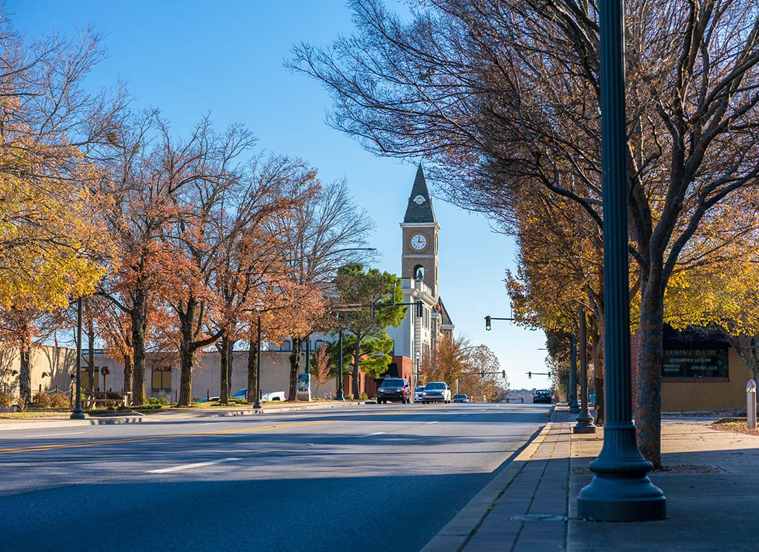 Coldwater, OH - Scenic View of Fall Colored Trees Along a Main Street in Coldwater Ohio with a Church Visible in the Background Against a Blue Sky